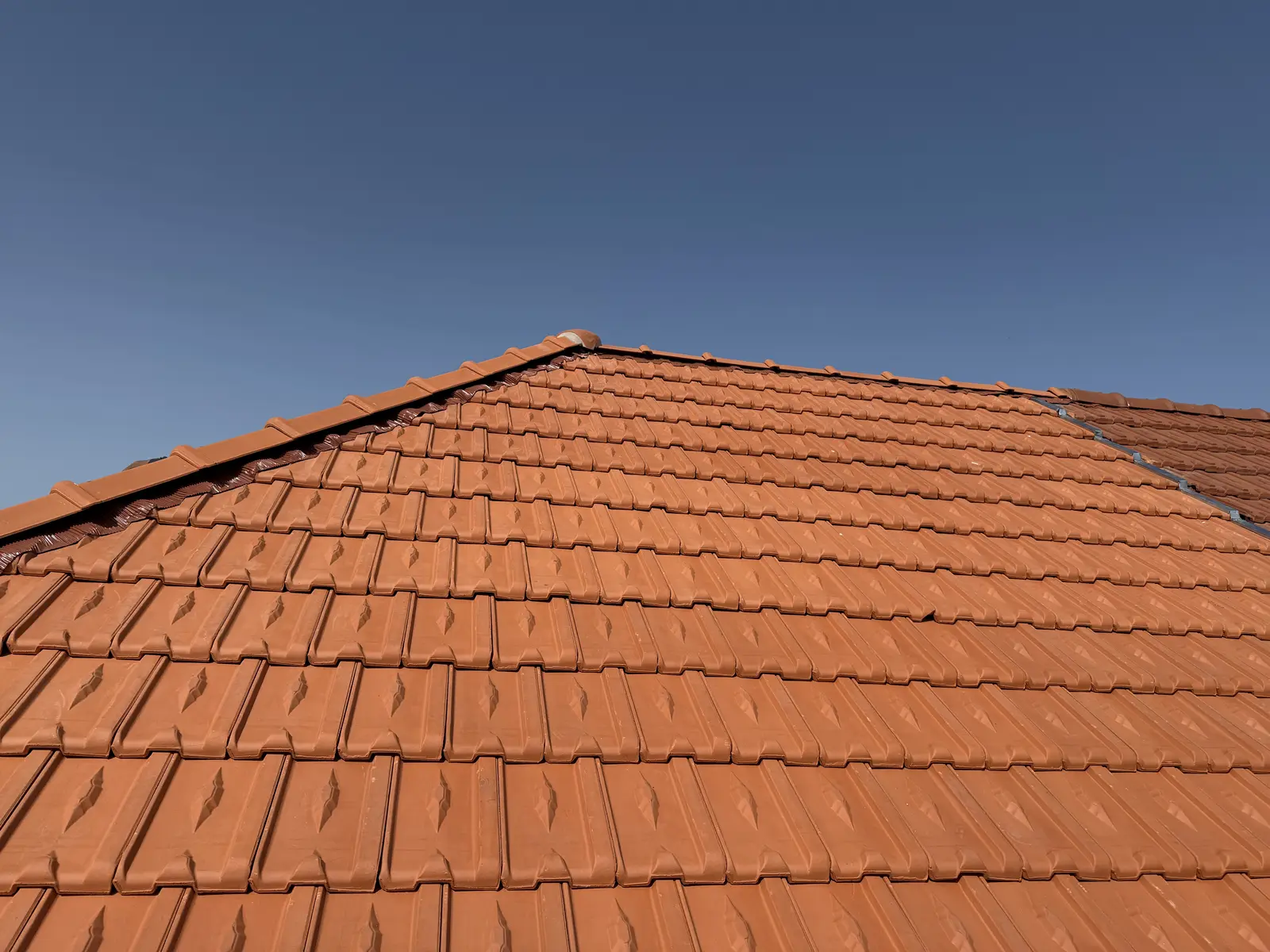 Toiture en tuiles neuves sous un ciel bleu